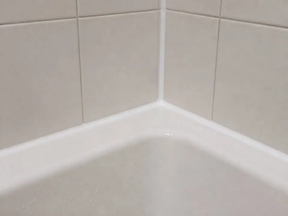Tub corner rebuilt with silicone after
