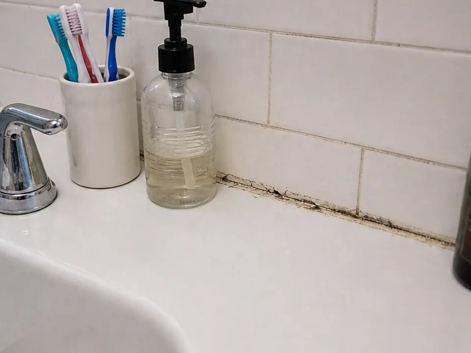 Pedestal sink backsplash before
