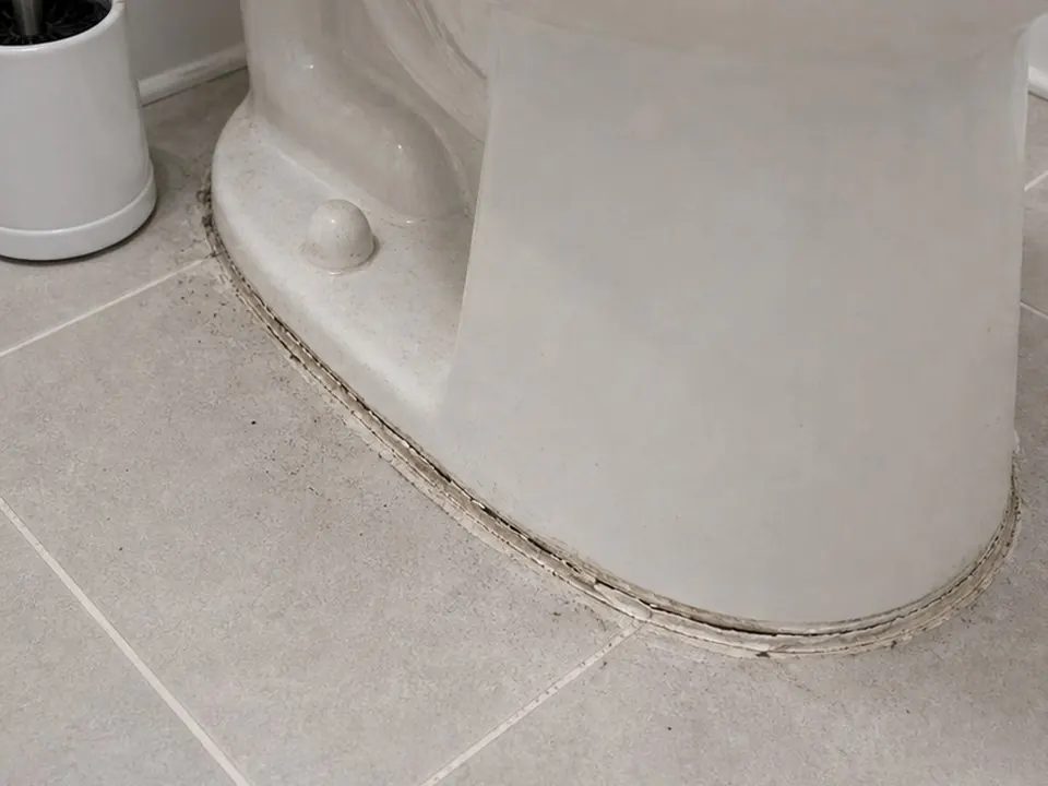 Toilet base caulk before